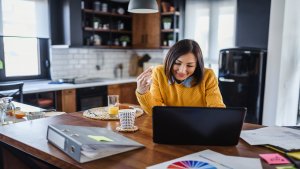 Young business entrepreneur woman working at home while having breakfast