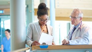 Two doctors discussing information on a document