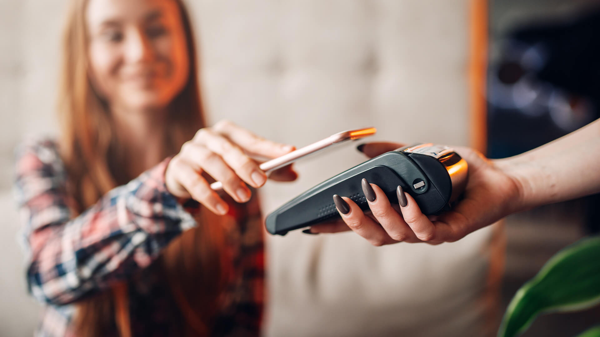 Woman making a contactless payment through her phone