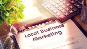 Clipboard with a local business marketing plan, on a table next to a calculator and a plant