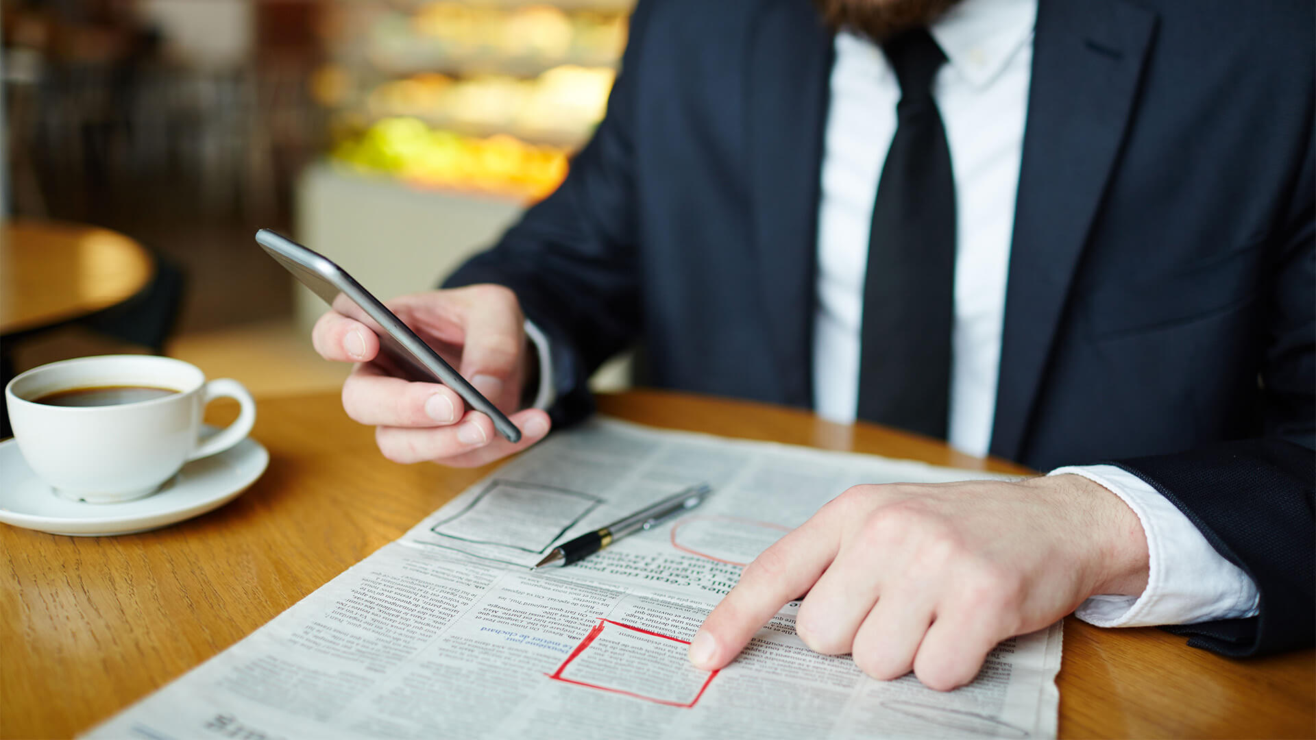 Business man in a suit looking over the job adverts in a newspaper