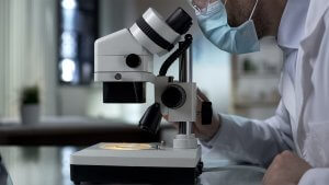 Scientist in a lab looking through a microscope
