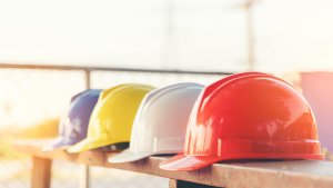 Safety helmets of different colours lined up on a table