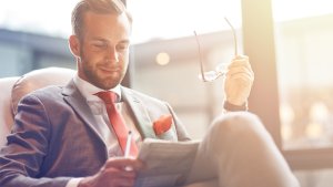 CEO sitting in an armchair reading from a newspaper