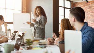 Cheerful businesswoman giving presentation to group