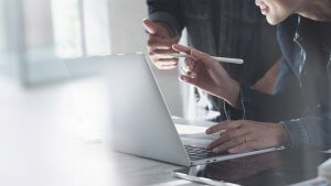 People sitting at at a table with a laptop discussing ideas