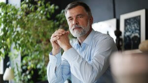 Mature professional businessman looking at camera and smiling.