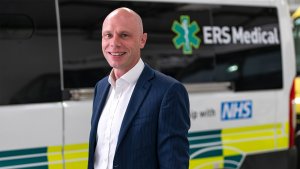 Andrew Pooley standing in front of an ERS Medical Ambulance
