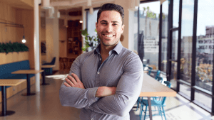 Portrait Of Businessman Standing In Modern Open Plan Office