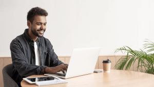 Young man sitting at a table using laptop