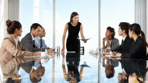 Group Of Business People Having Board Meeting Around Glass Table