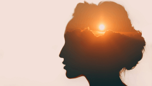 Woman with sun over clouds in her head. Mental health concept
