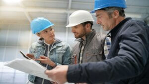 Team of construction workers talking in empty warehouse