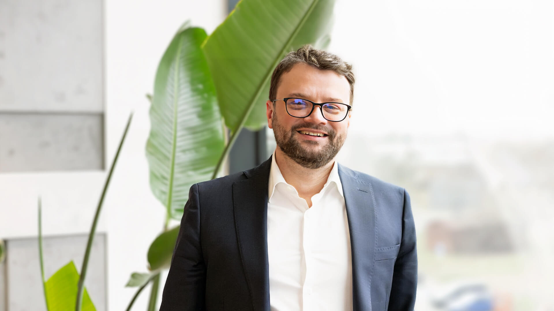 man in suit and glasses smiling