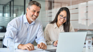 Happy smiling diverse colleagues executives team two professional managers looking at laptop