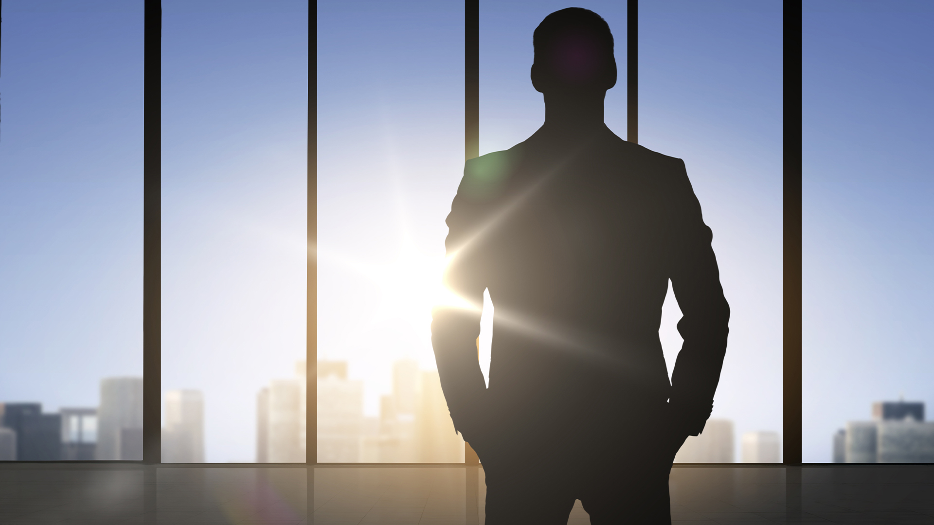 silhouette of business man over office background