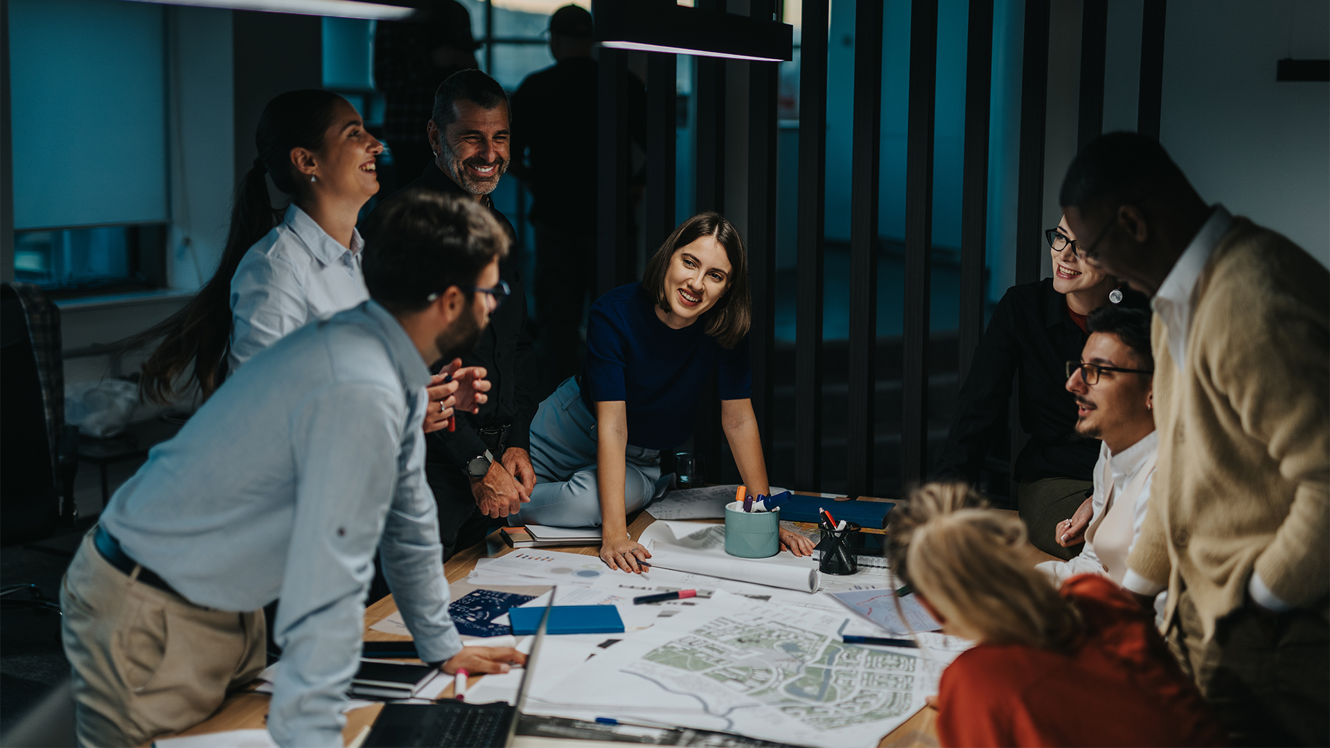 Diverse group of business people gather around a table, actively brainstorming and sharing ideas for a project.