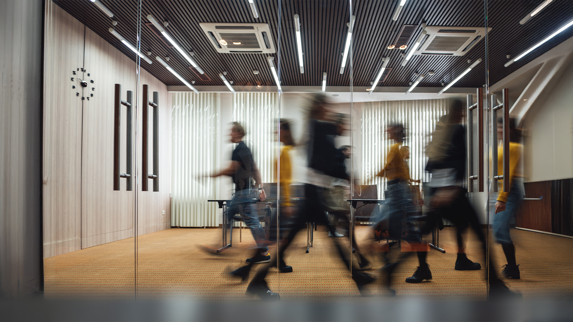 Group of office employees at coworking center. Business people walking at modern open space. Motion blur