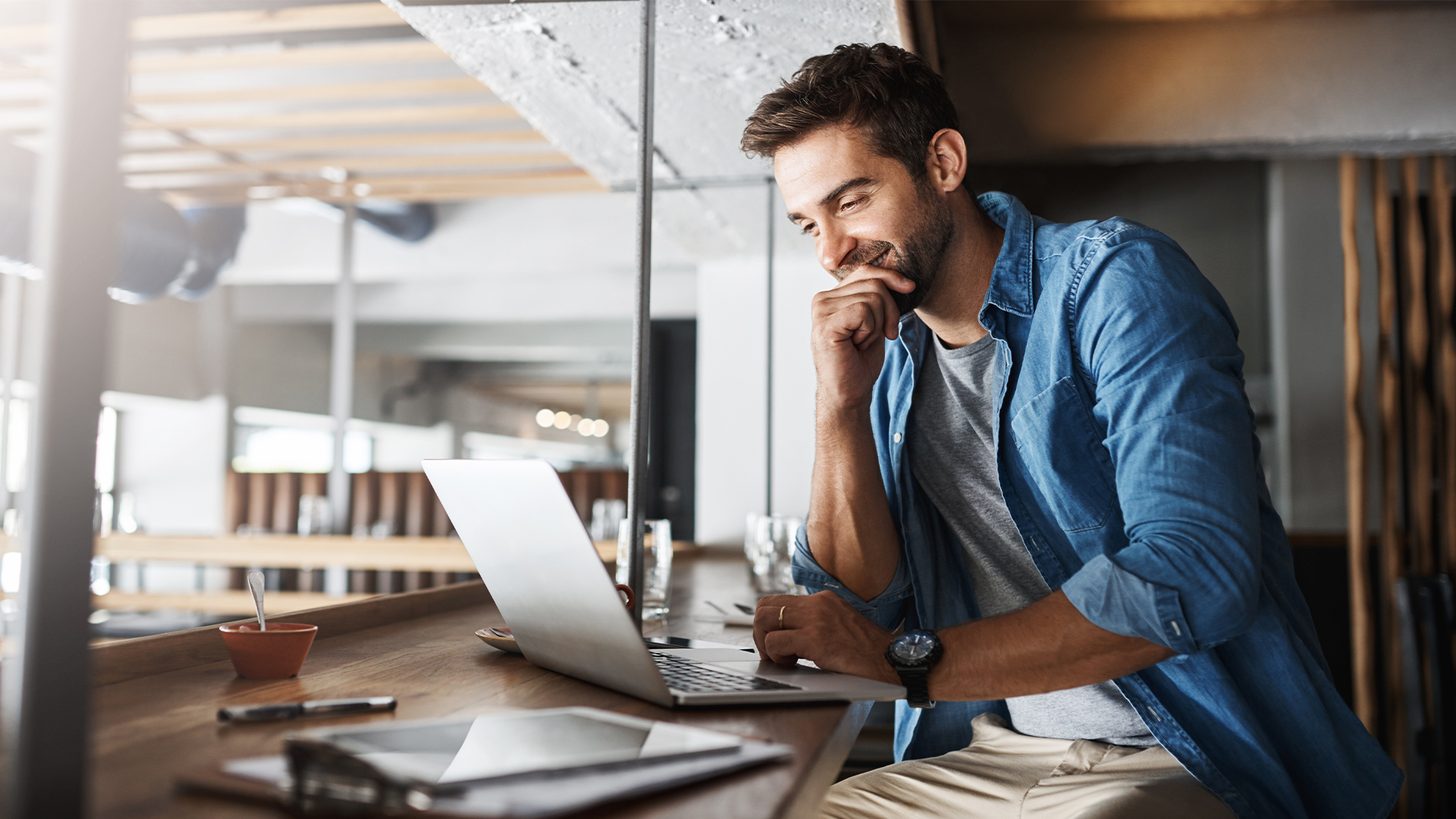 Man in coffee shop, laptop and small business owner, entrepreneur in hospitality management and connectivity.